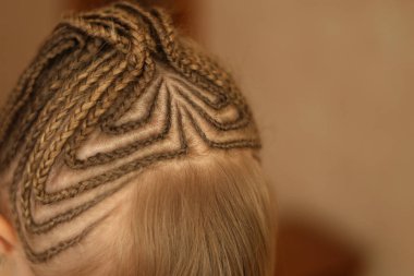 Afrika üzerinden bir saç kesimi ile küçük kız örgü, Amerikan pigtails, ince, bir sihirbaz, bir saç modeli çorap sürecinde, metin için arka plan çalışmaları