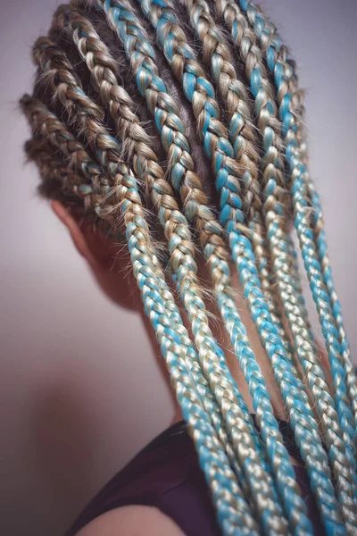 Cornrows mulheres Uma mulher com um corte de cabelo em um fundo branco, tranças apertadas trançadas em uma cauda, material artificial tecido em seu cabelo — Fotografia de Stock