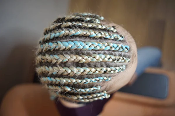 Mujeres cornrows Una mujer con un corte de pelo sobre un fondo blanco, trenzas apretadas trenzadas en una cola, material artificial tejido en su cabello — Foto de Stock