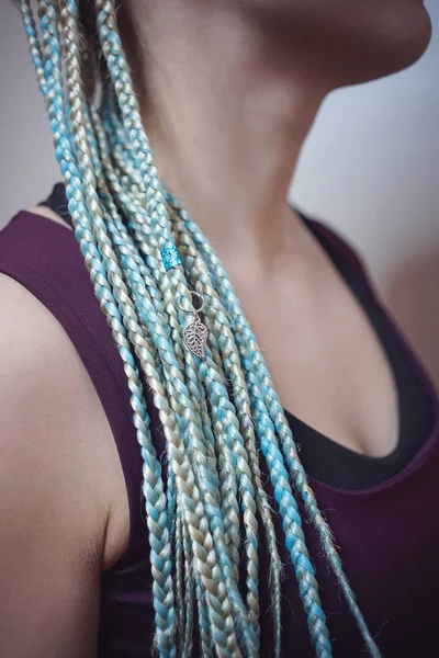 Cornrows donne Una donna con un taglio di capelli su uno sfondo bianco, trecce strette intrecciate in una coda, materiale artificiale tessuto nei capelli — Foto Stock