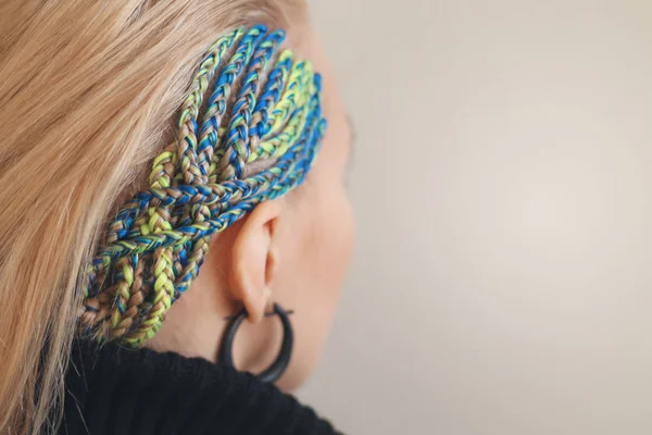 Cabelo azul firmemente trançado no templo da menina, o fundo para as inscrições salão de beleza — Fotografia de Stock