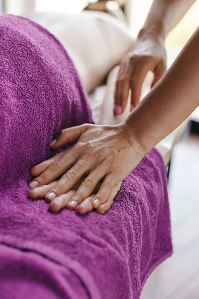 Massör gör massage till klienten, massagesalong, sport, avkopplande, skönhetssalong, flickan ligger på soffan — Stockfoto