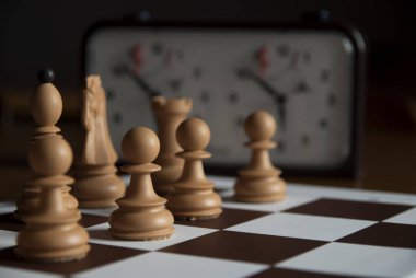 Satranç tahtası bir kaç satranç taşları ve satranç saat arkada