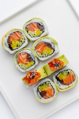 Sushi, beyaz bir arkaplanda izole bir şekilde yuvarlanıyor.