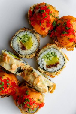 Baked sushi roll with salmon close-up on a white background isolated