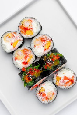 Sushi, beyaz bir arkaplanda izole bir şekilde yuvarlanıyor.