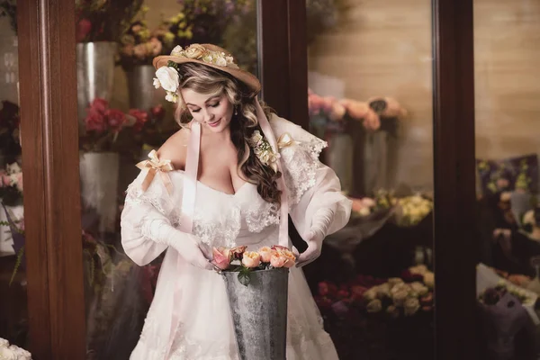 Menina em vestido de renda branca na loja de flores — Fotografia de Stock