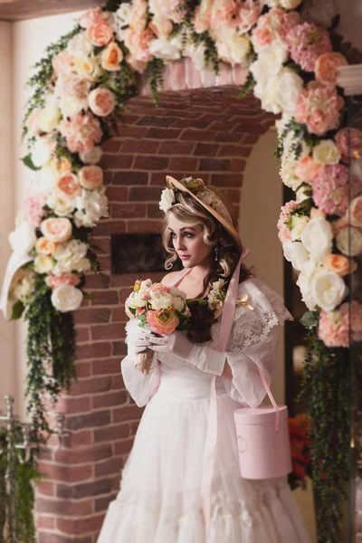Flicka i hatt blomsterarrangemang — Stockfoto