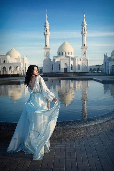 Женщина на фоне белой мечети — стоковое фото
