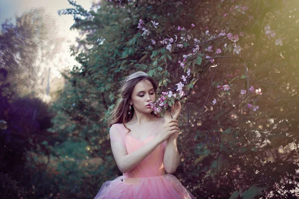 Dívka v růžových šatech v květinové zahradě — Stock fotografie