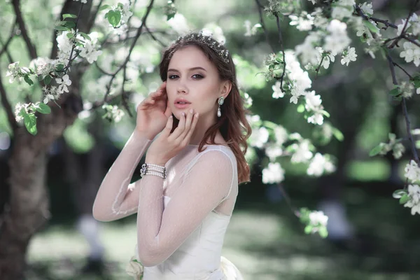 Vackra unga bruden i en blommande trädgård — Stockfoto