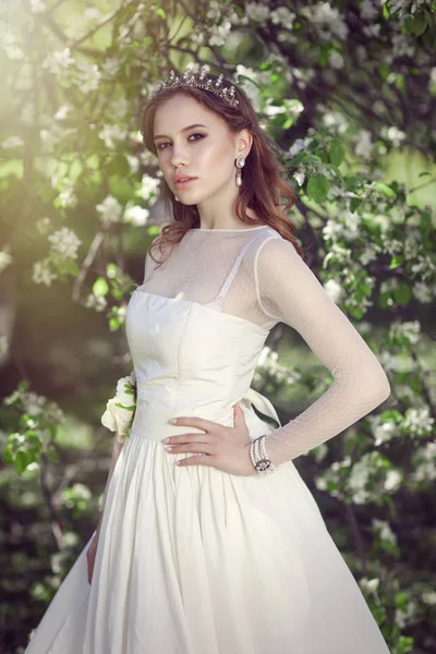 Mooie jonge bruid in een bloeiende tuin — Stockfoto