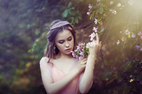 Menina em um vestido rosa em um jardim de flores — Fotografia de Stock