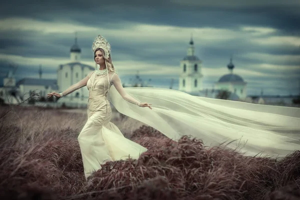 Lány a fehér ruhában, háttérben a templom — Stock Fotó