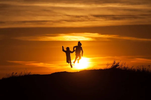 Deux silhouettes d'un enfant au coucher du soleil — Photo