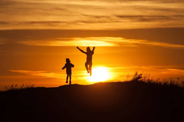 Deux silhouettes d'un enfant au coucher du soleil — Photo