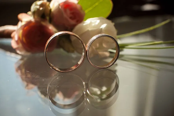 Odraz dva snubní prsteny ve skle — Stock fotografie