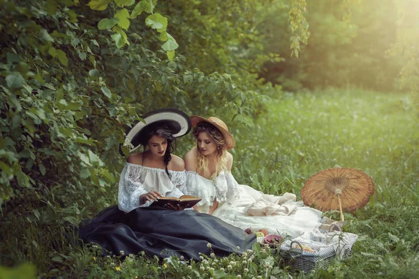 İki güzel kız doğada bir kitap okuma — Stok fotoğraf