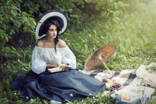 Krásná brunetka v šatech čtení knihy — Stock fotografie