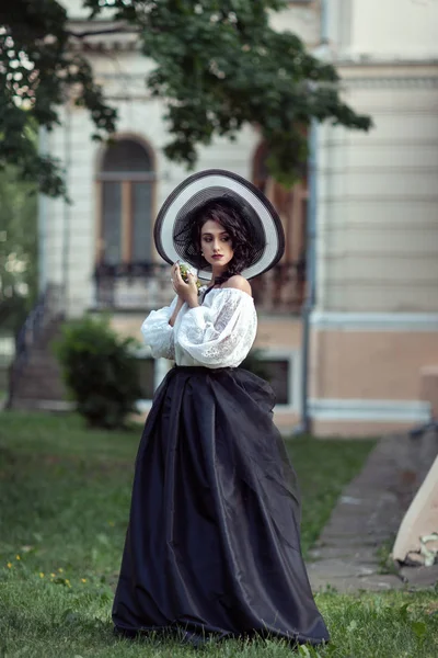 Krásná brunetka v velké černé a bílé čepice — Stock fotografie