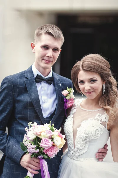 Novia joven y novio con un ramo de flores — Foto de Stock