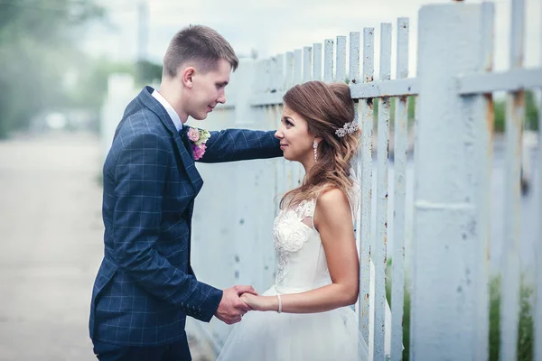 Sposi appena sposati vicino alla recinzione di ferro. Prospettiva lineare — Foto Stock
