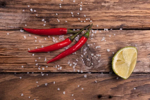 Chili peppar, salt och lime på en träskiva — Stockfoto