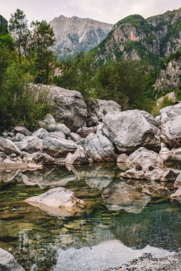 Arnavutluk Alpleri 'ndeki Theth Ulusal Parkı' ndaki Şala Nehri 'nin dağ manzarası, popüler seyahat beldesi. Kayalık nehir yatağının manzarası, berrak su ve dağ manzarasındaki yoğun yaz bitkileri..