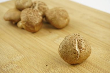 Ahşap arka planda taze Shiitake Mantarı. Yemek Hazırlama. Seçici Odak. (Lentinula edodes)