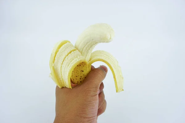 Hand holding a peel banana isolated white background. Healthy nutritious Food.