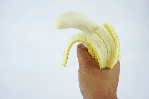 El bir soyma muz izole beyaz arka plan tutarak. Sağlıklı besleyici Gıda.