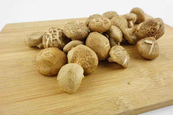 Ahşap arka planda taze Shiitake Mantarı. Yemek Hazırlama. Seçici Odak. (Lentinula edodes)