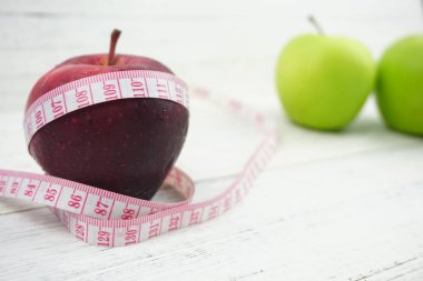 Ahşap ba üzerinde ölçüm bandı ile Yeşil ve Kırmızı Elmalar kapatın