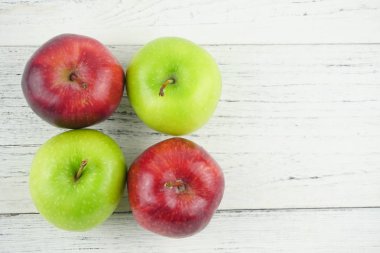 Ahşap arka plan doku üzerinde kırmızı ve yeşil elma. Sağlıklı Gıda 