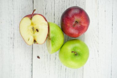 Ahşap arka plan doku üzerinde kırmızı ve yeşil elma. Sağlıklı Gıda 