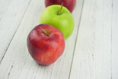 Ahşap arka plan doku üzerinde kırmızı ve yeşil elma. Sağlıklı Gıda 