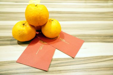 Çin Yeni Yılı kutlaması için ahşap arka plan üzerinde angpow paketleri ile Mandalina portakal veya Lokam