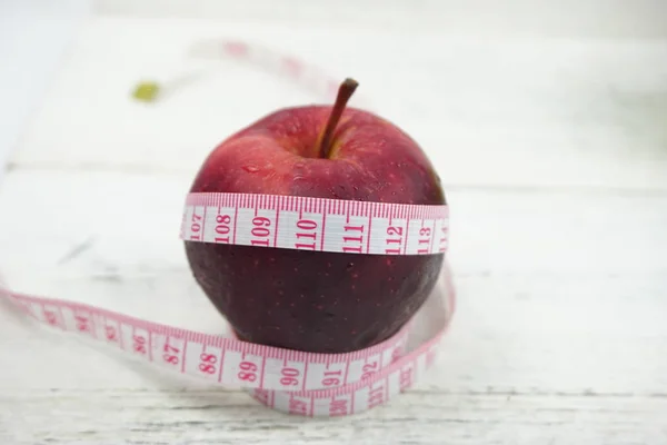 Ahşap ba üzerinde ölçüm bandı ile Yeşil ve Kırmızı Elmalar kapatın