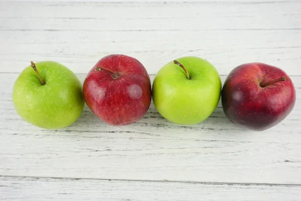 Ahşap arka plan doku üzerinde kırmızı ve yeşil elma. Sağlıklı Gıda 