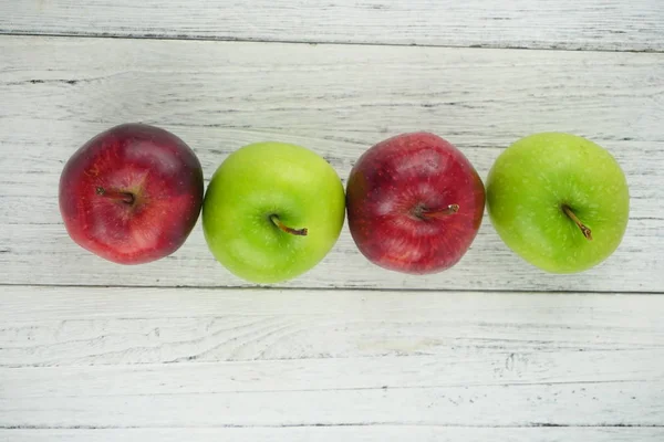 Ahşap arka plan doku üzerinde kırmızı ve yeşil elma. Sağlıklı Gıda 