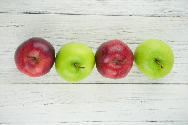 Ahşap arka plan doku üzerinde kırmızı ve yeşil elma. Sağlıklı Gıda 