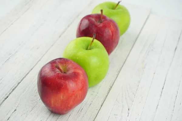 Piros és zöld alma a fa háttér textúra. Egészséges táplálkozás — Stock Fotó
