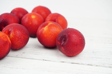 Ahşap doku arka plan üzerinde olgunlaşmış taze Erik