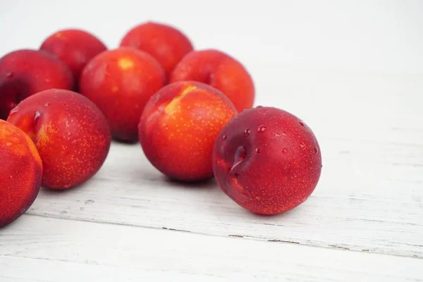 Ahşap doku arka plan üzerinde olgunlaşmış taze Erik