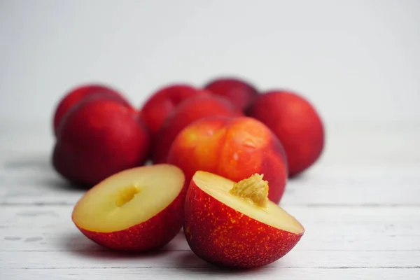 Ahşap doku arka plan üzerinde olgunlaşmış taze Erik