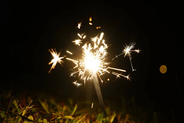 Yeni Yıl Partisi Sparkle Fire Burn yere bir zemin çim üzerinde. Seçici Odak 