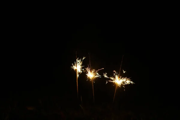 新年派对闪闪发光的火焰燃烧在黑色背景 选择性对焦 — 图库照片