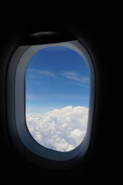 Plane window view with blue sky and sea