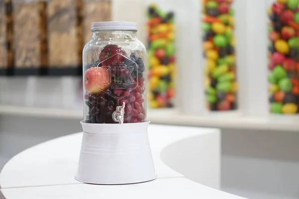 Taze Meyve Elma ve üzüm bir dispenser cam kavanoz içinde. Sağlıklı Gıda Yaşam Tarzı. Su aşılayın. Seçici Odak