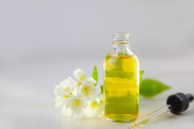 Çiçeklerin özü beyaz bir arka planda güzel bir cam kavanozda